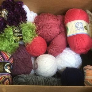Variety box of a selection of yarns, knitting needles, crochets needs and tools.